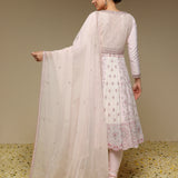 Woman wearing a light pink traditional outfit with a matching dupatta against a neutral background