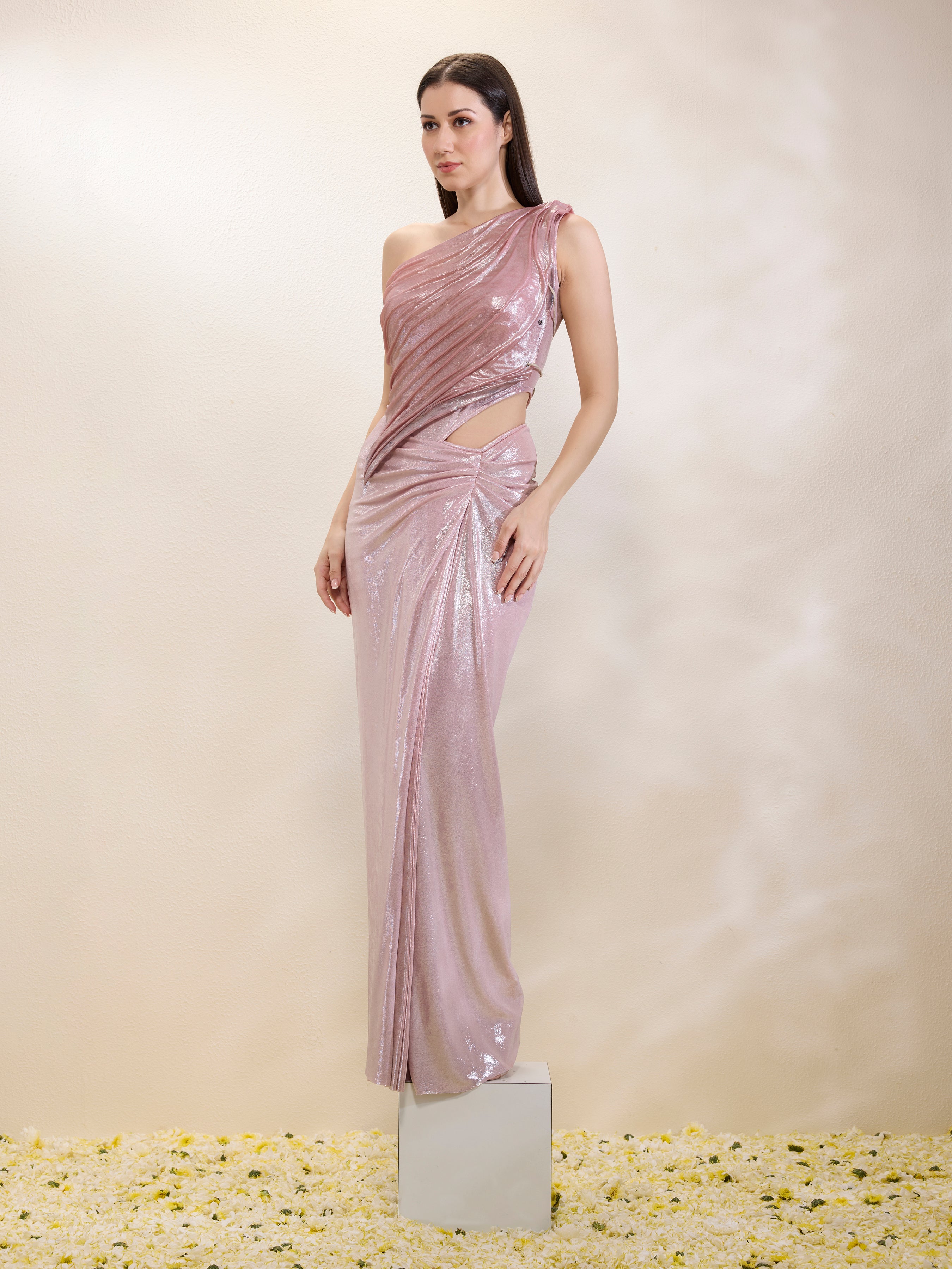 Woman wearing a one-shoulder pink evening gown on a neutral background