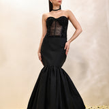Woman wearing a black strapless gown with a balloon skirt