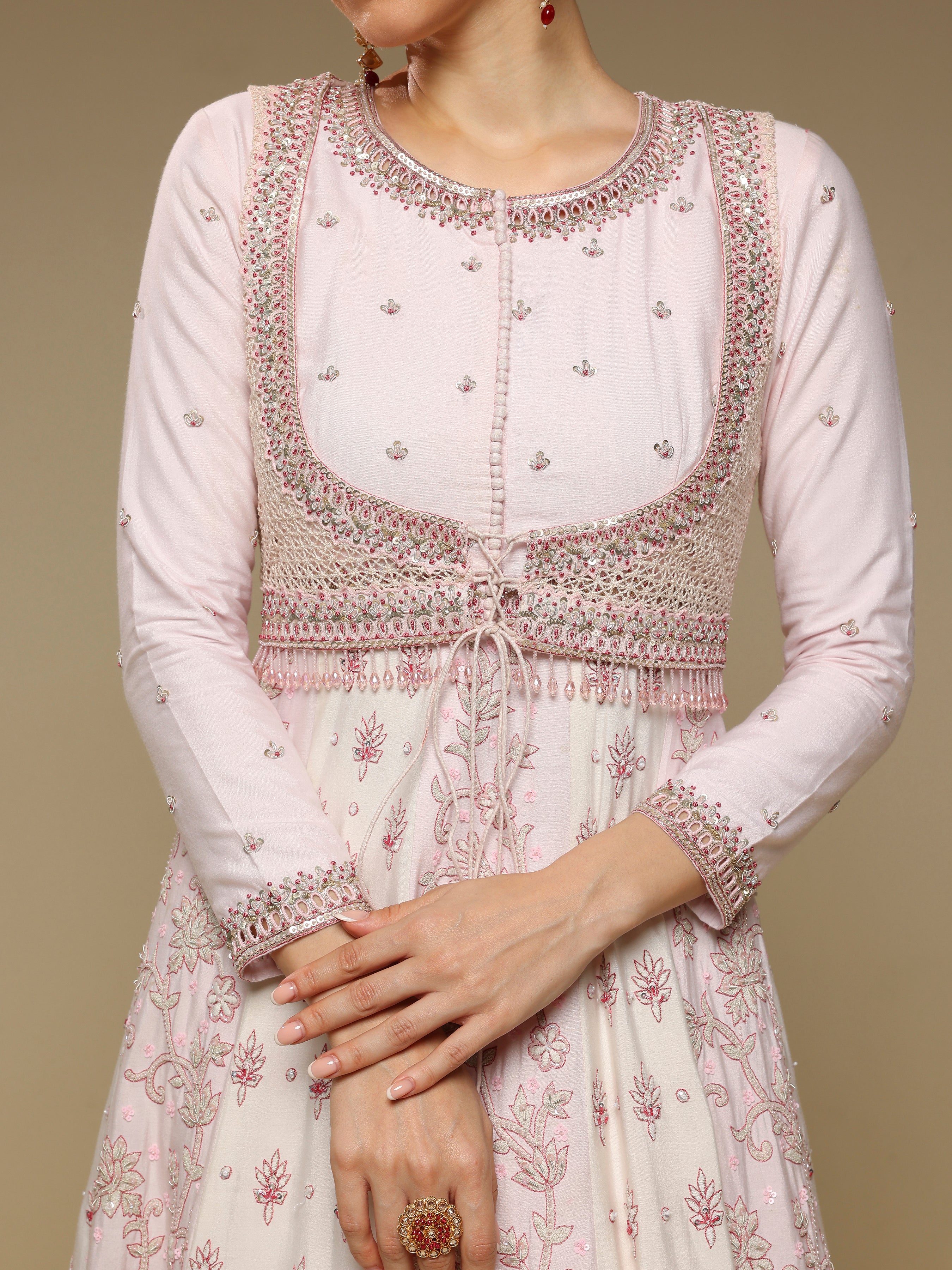 White traditional outfit with intricate embroidery on a beige background