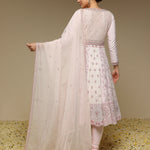 Woman wearing a light pink traditional outfit with a matching dupatta against a neutral background