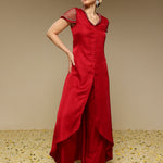Woman wearing a red kurta set with a plain background