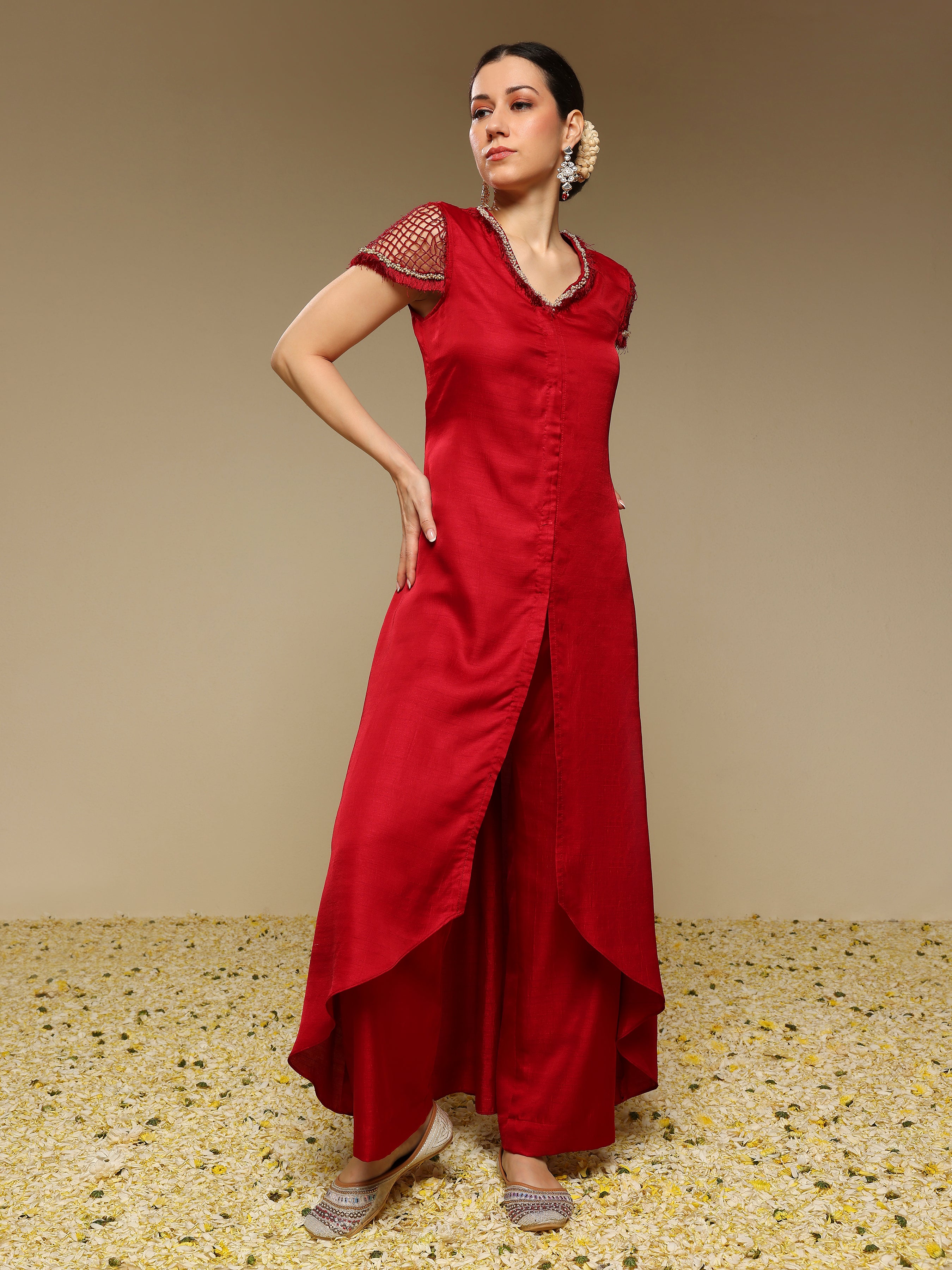 Woman wearing a red kurta set with a plain background