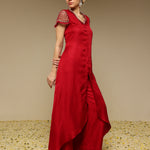 Woman wearing a red kurta set with net sleeves with a textured background