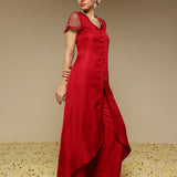 Woman wearing a red kurta set with net sleeves with a textured background