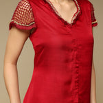 Red dress with lace details on a beige background