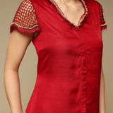 Red dress with lace details on a beige background