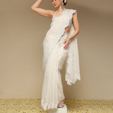 Woman in an ivory scalloped saree with intricate zardozi embroidery