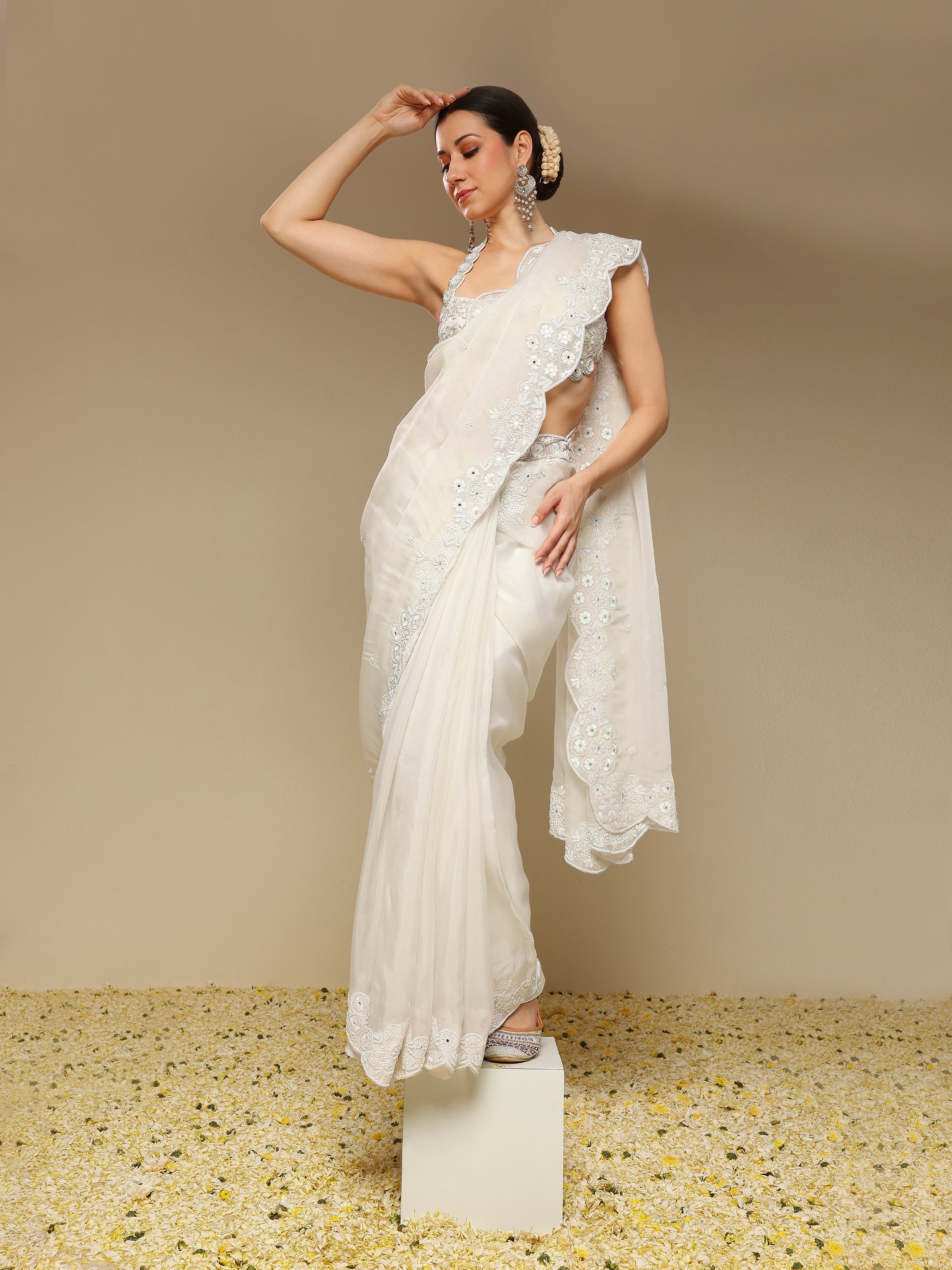 Woman in an ivory scalloped saree with intricate zardozi embroidery