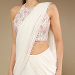 Close-up of zardozi embroidery on blouse and pearl drop detailing on ivory saree pallu