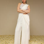 Front view of woman wearing an ivory predraped pant saree set
