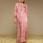 Woman wearing a pink and white patterned dress on a beige background
