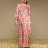 Woman wearing a pink and white patterned dress on a beige background