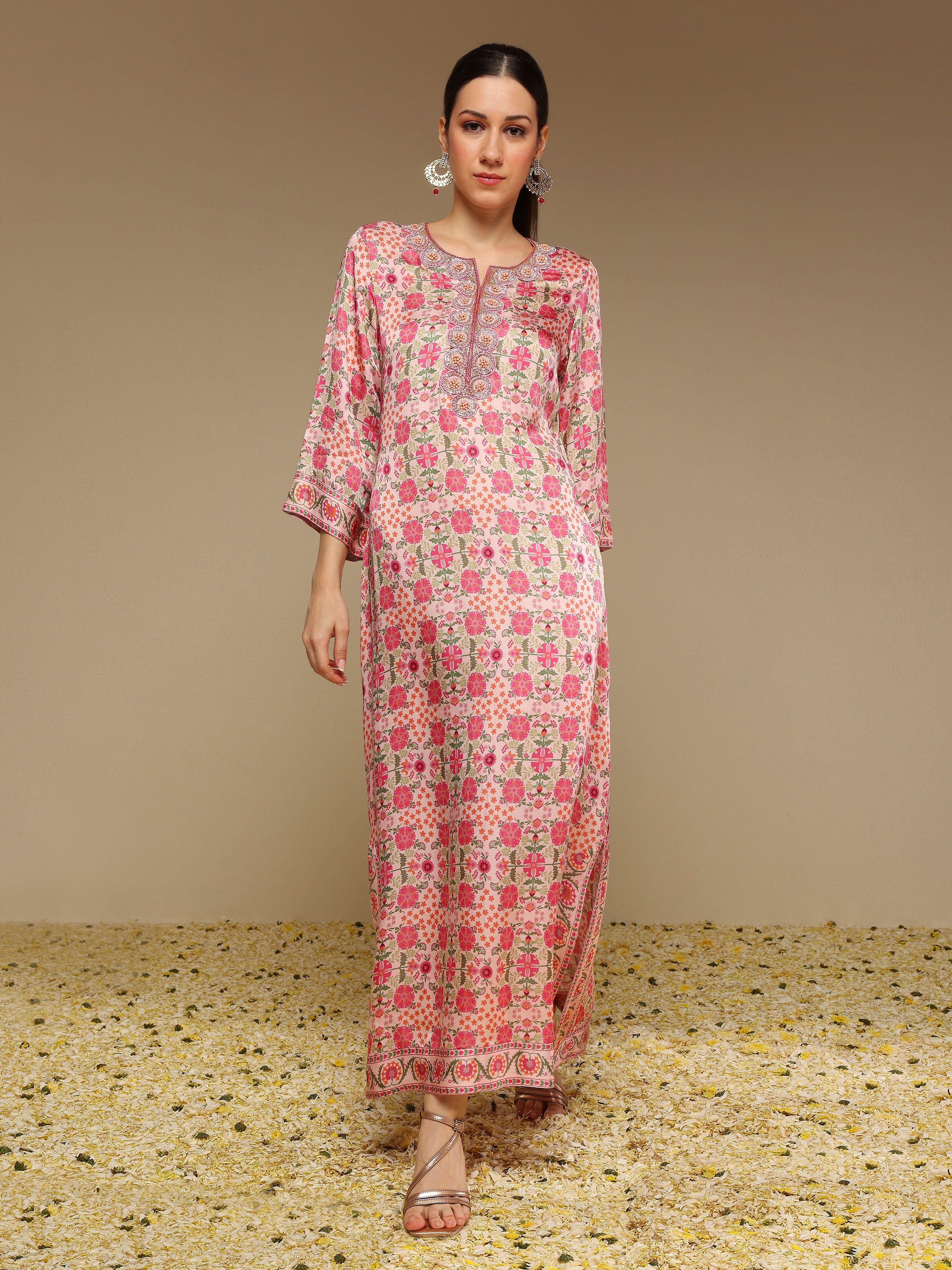 Woman wearing a pink and white patterned dress on a beige background