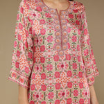 Floral patterned dress worn by a model on a beige background