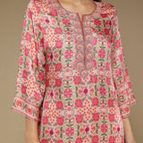 Floral patterned dress worn by a model on a beige background
