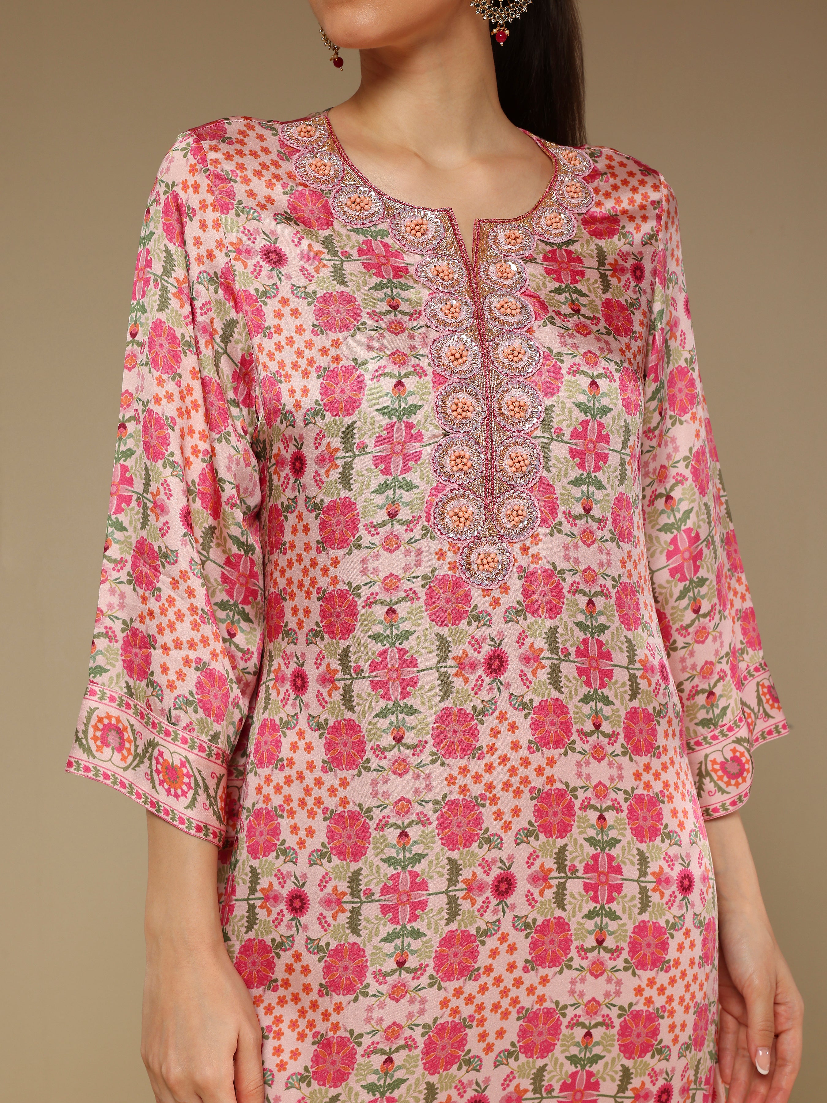 Floral patterned dress worn by a model on a beige background
