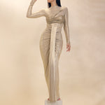 Woman in a long, elegant dress standing on a pedestal against a plain background