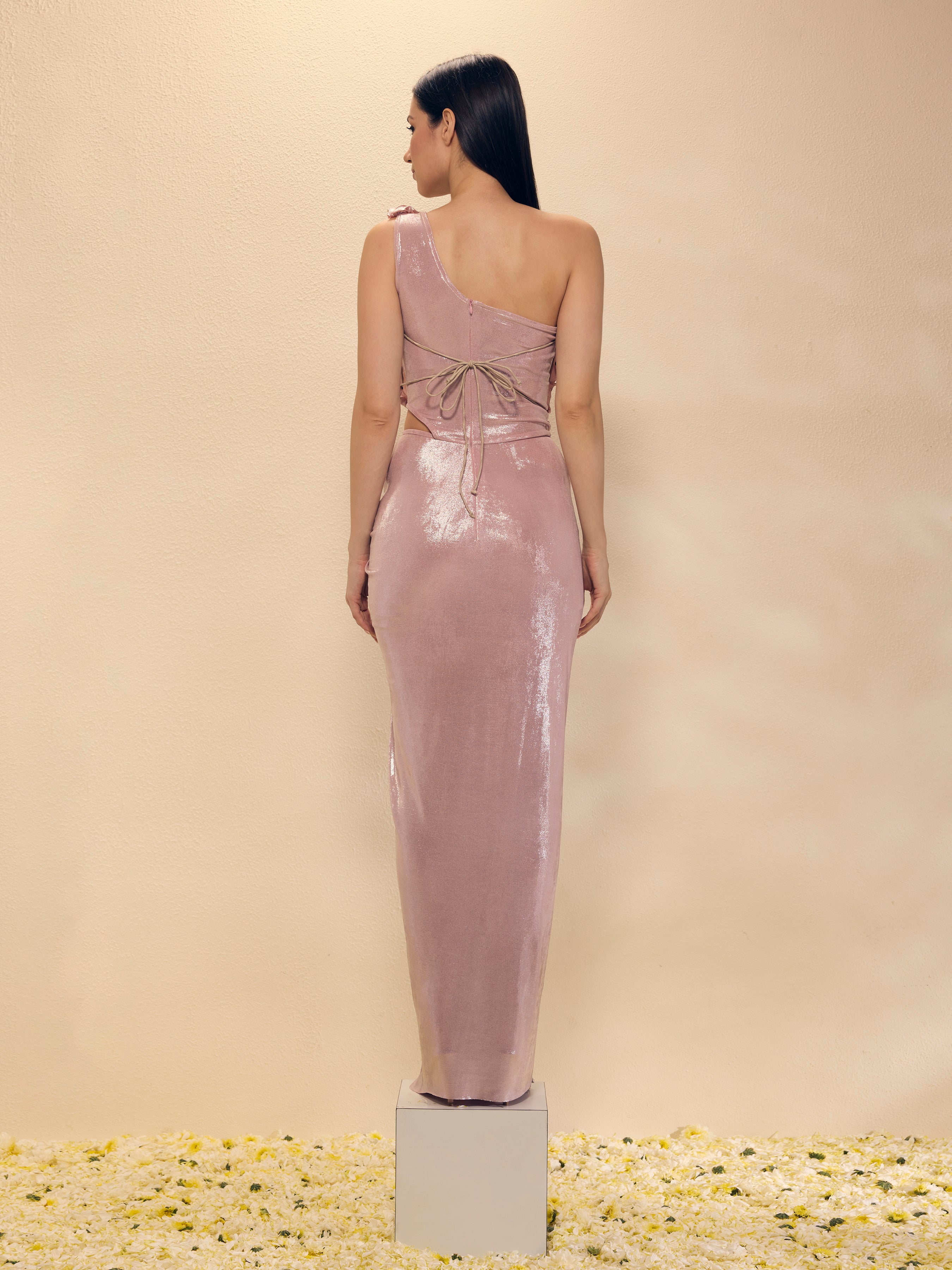 Woman wearing a one-shoulder pink dress on a beige background