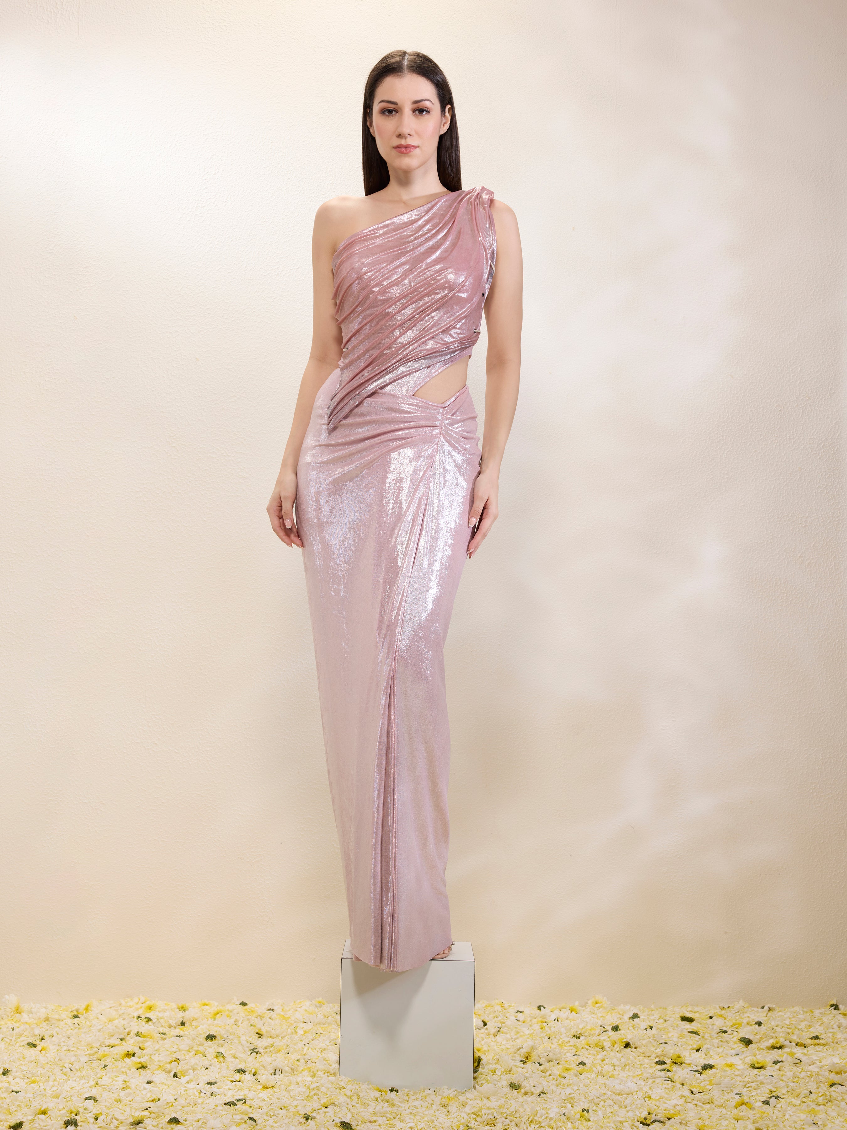 Woman wearing a one-shoulder pink evening gown against a plain background