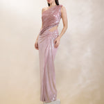 Woman wearing a one-shoulder pink evening gown on a neutral background