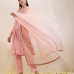 Woman wearing a pink traditional outfit with a matching dupatta on a light background