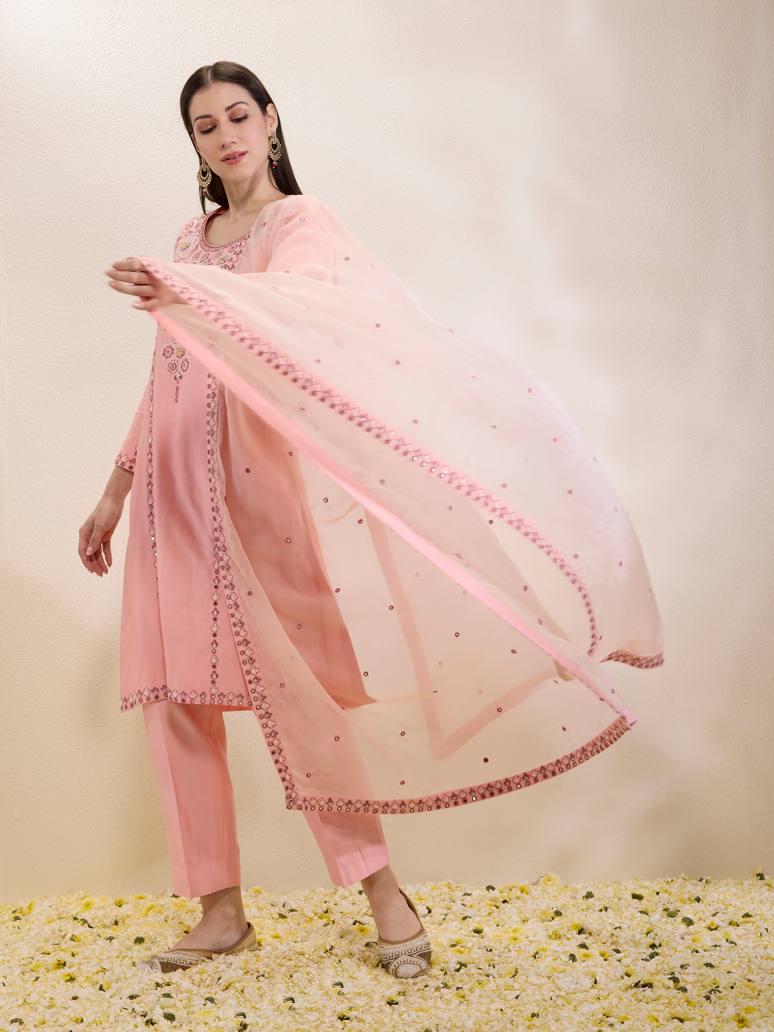 Woman wearing a pink traditional outfit with a matching dupatta on a light background