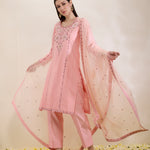 Woman wearing a pink traditional outfit with a matching dupatta on a light background