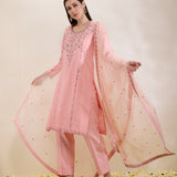 Woman wearing a pink traditional outfit with a matching dupatta on a light background