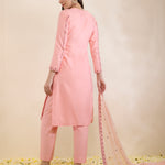Woman wearing a pink traditional outfit with a matching dupatta on a light beige background