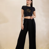 Woman wearing a black outfit with a logo on a beige background