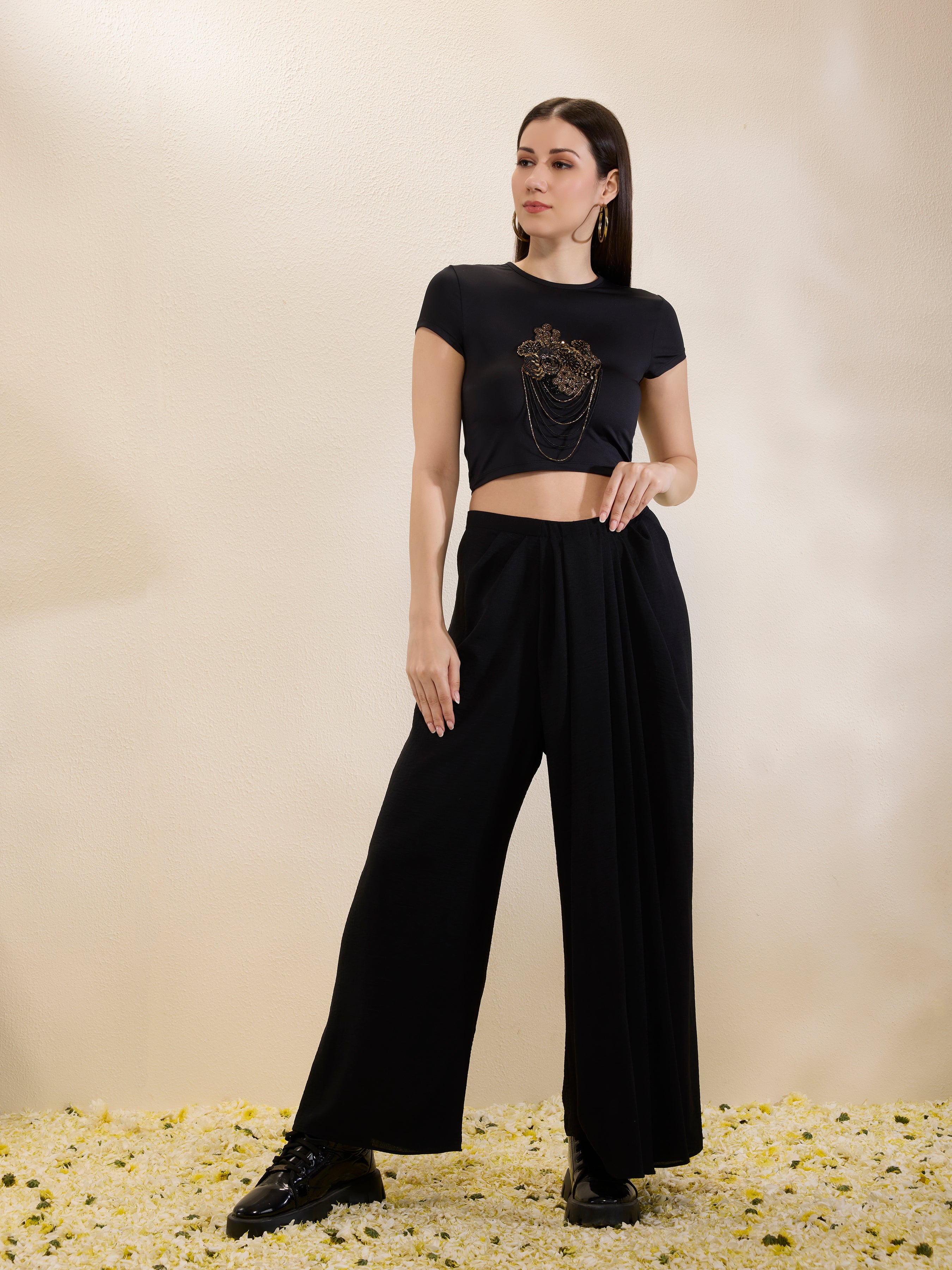 Woman wearing a black outfit with a logo on a beige background