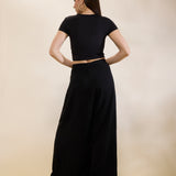 Woman wearing a black outfit with a cutout design on a beige background