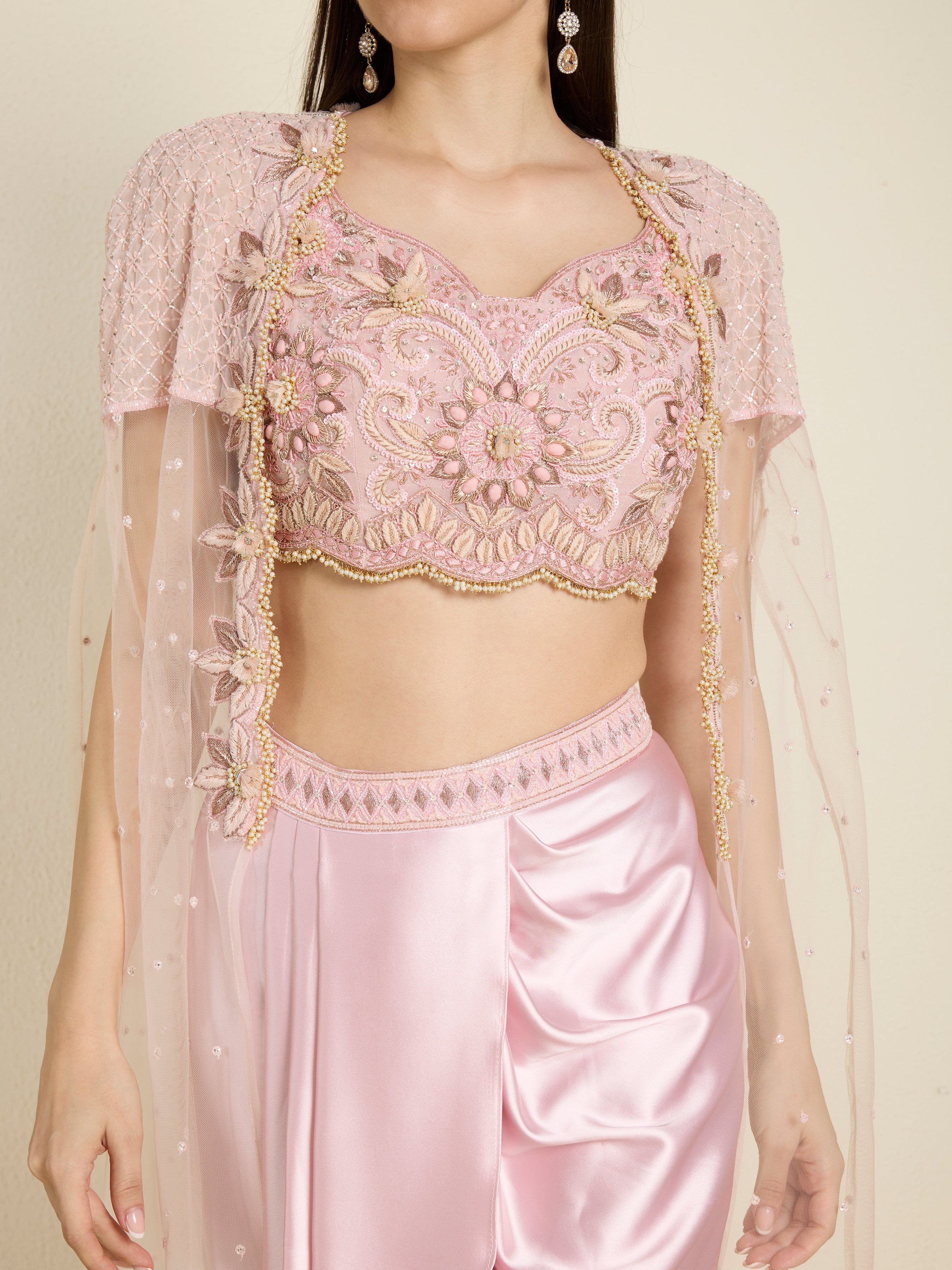 Pink embroidered blouse with matching skirt on a plain background