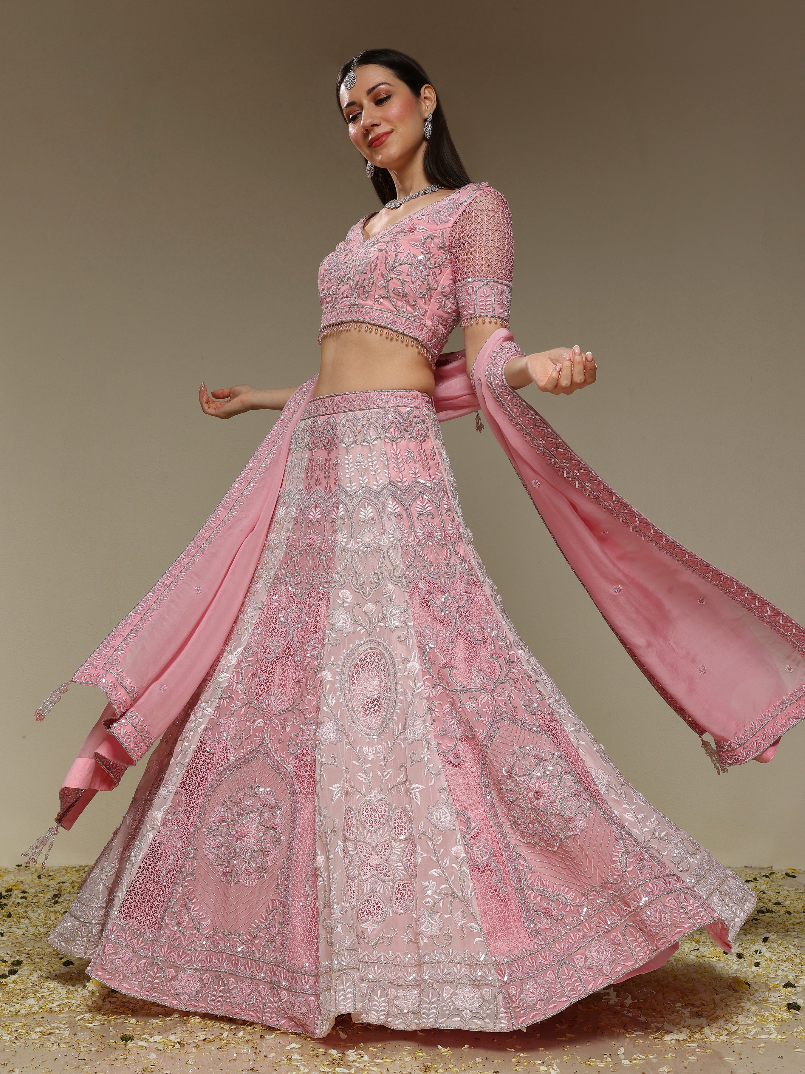 Woman wearing a hand embroidered pink lehenga set