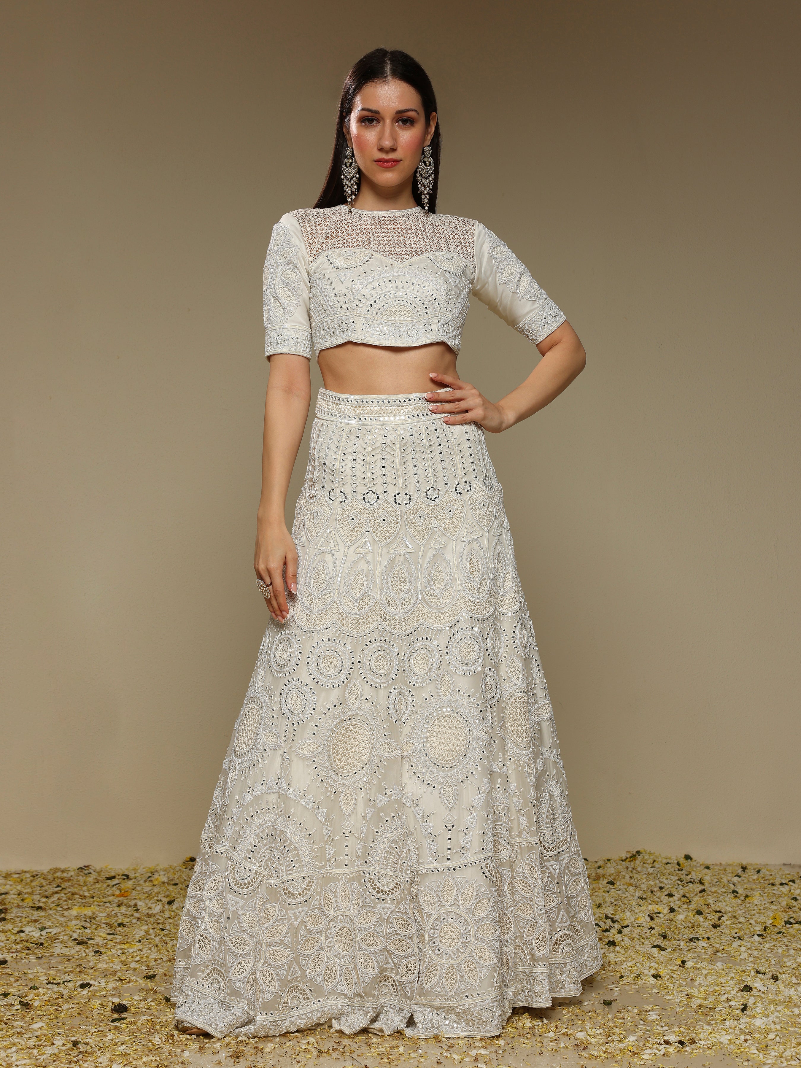 Woman wearing an ivory lehenga outfit showcasing pearl and threadwork embellishments