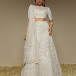 Woman wearing an ivory embroidered organza lehenga with pearl and sequin work
