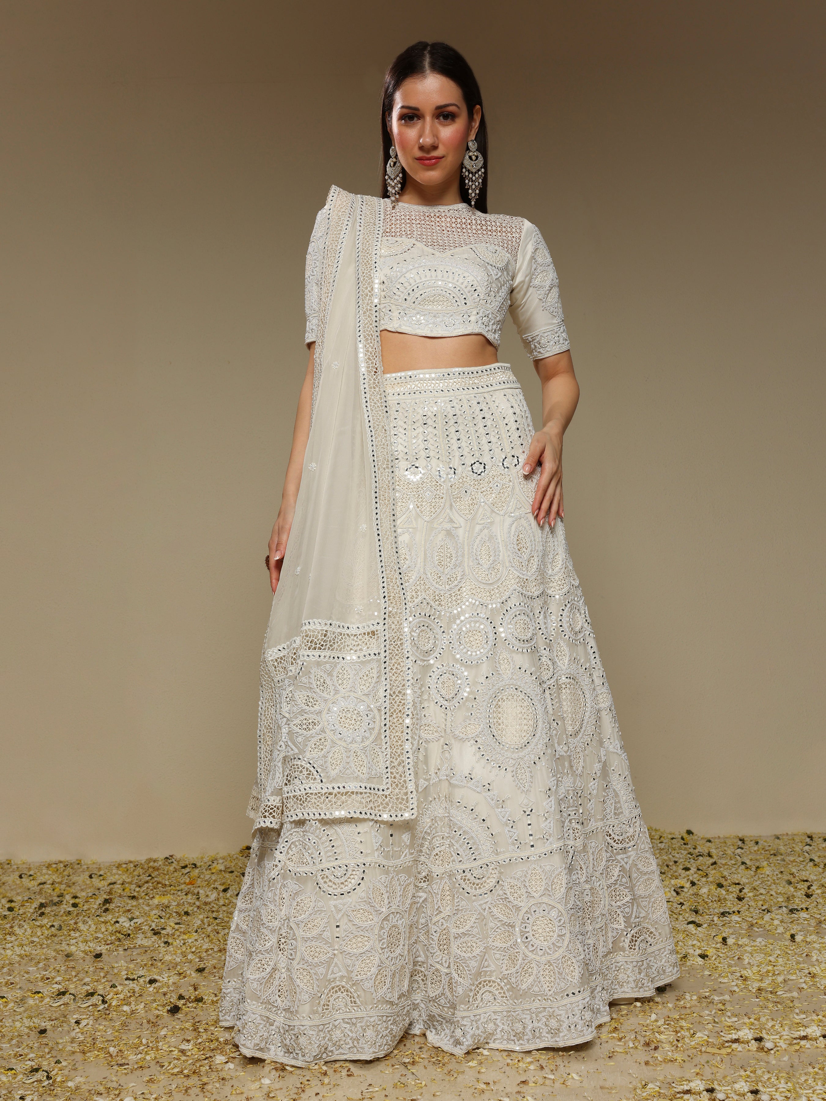 Woman wearing an ivory embroidered organza lehenga with pearl and sequin work